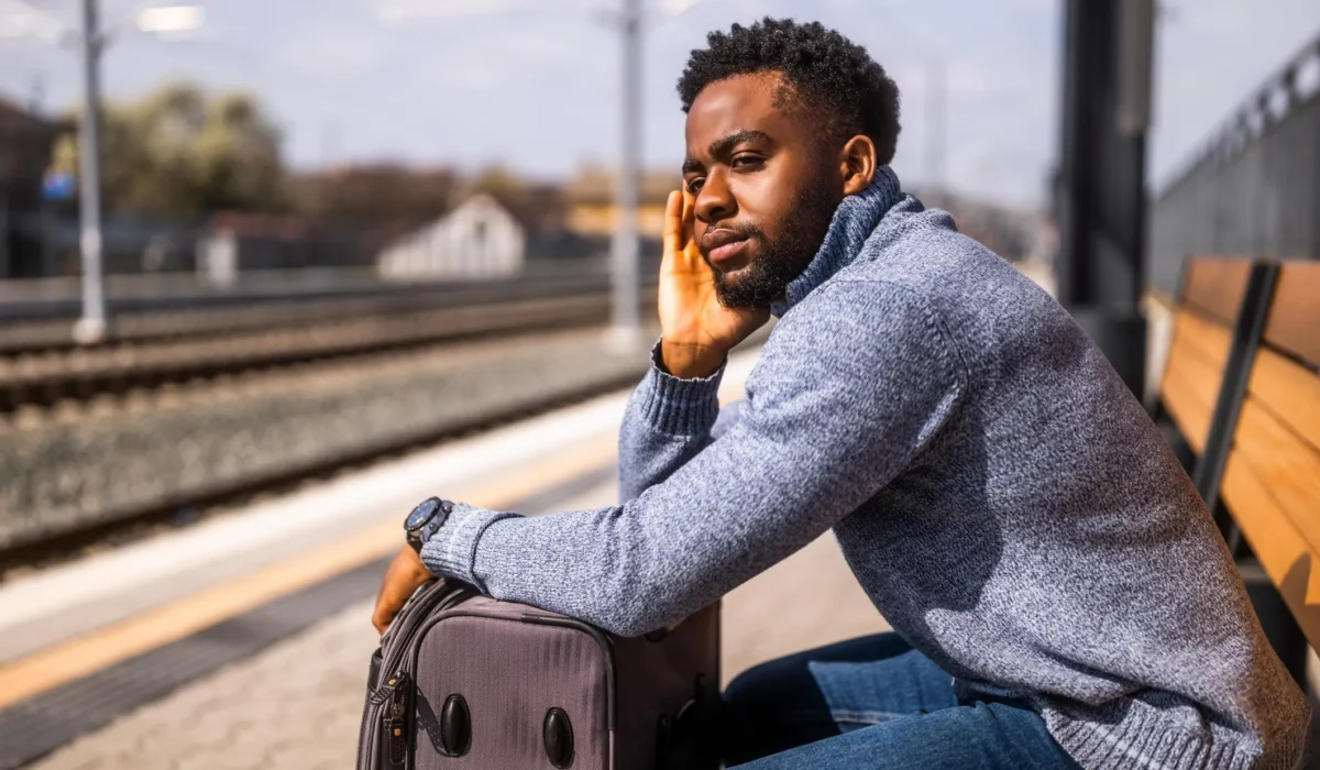 Jeune homme pensivement assis à une table, le visage appuyé sur sa main, illustrant la réflexion et les dilemmes de la jeunesse.